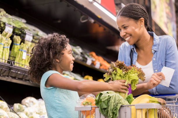 istock Young daughter helps mom grocery shop 936496976
