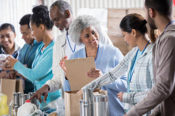 istock Food bank manager instructs volunteers 936497160