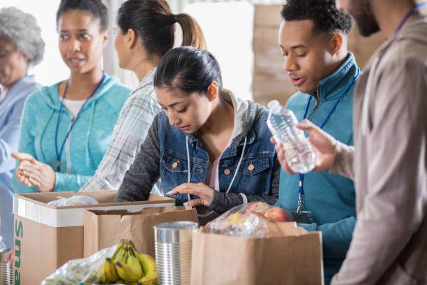 istock Group of volunteers sort through food donations 936497188