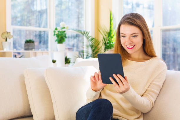 istock Young woman reading with an e-reader in a large room 936503822