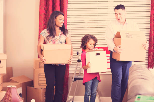 istock Multi-ethnic family packs, unpacks moving boxes in new home. 936504216