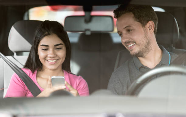 istock Couple driving and using a GPS app on their cell phone 936506446