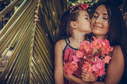 Outdoor Portrait Of Loving Mother  kisses her daughter