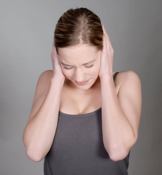 istock woman holding her ears with hands 936520804