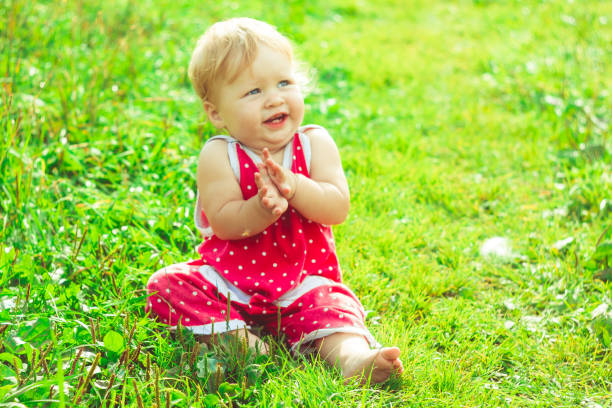 The child is sitting on the grass
