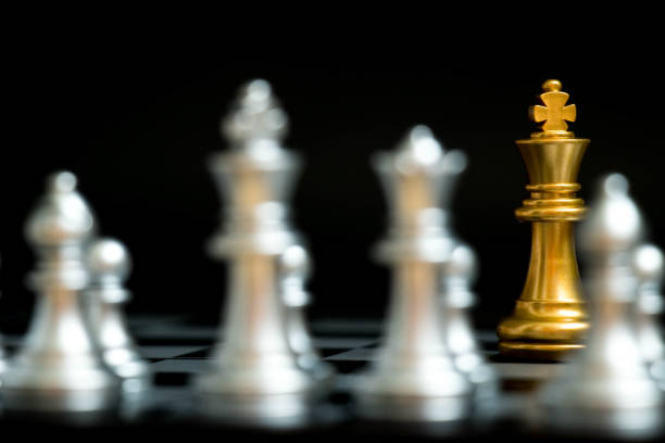 istock Gold king in chess game face with the another silver team on black background (Concept for company strategy, business victory or decision) 936531804