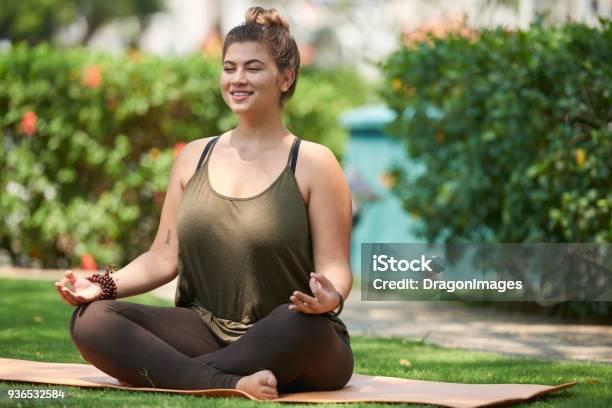 Smiling Young Woman Doing Yoga Stock Photo - Download Image Now - Yoga, Overweight, Women