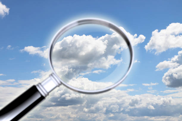 istock Air pollution research. Concept image whit magnifying glass against a cloudy sky - 936532936