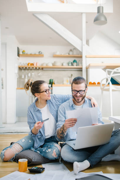 Couple using credit card Young couple paying bills with credit card credit card women internet currency stock pictures, royalty-free photos & images