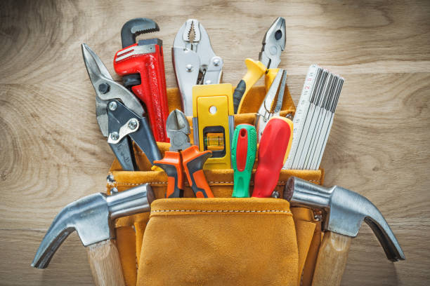 istock Set of tools in leather construction belt on wooden board 936537076