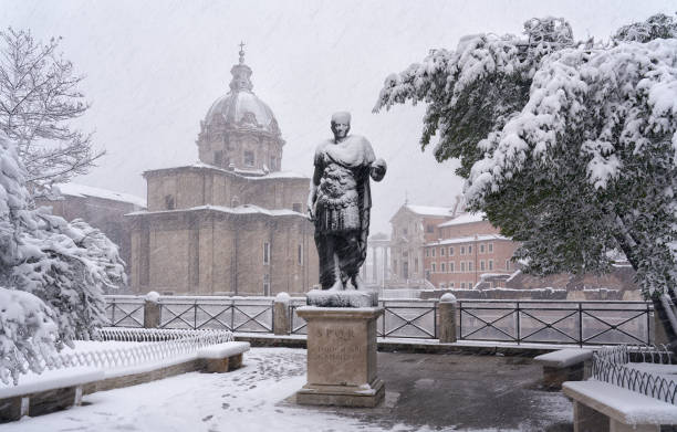 Snow covered statue of emperor Julius Caesar along Via dei Fori Imperiali