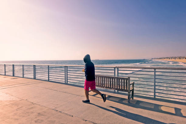 istock young man runing on manhattan beach pier in los angeles 936552238