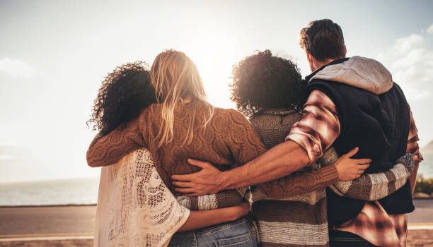 istock Friends standing together and looking at the sea 936552642