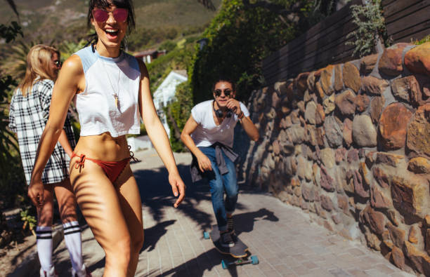 istock Cool young woman skateboarding with her friends 936563126
