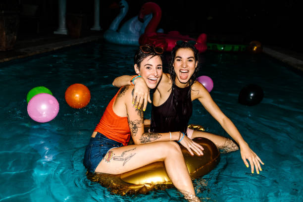 istock Female friends enjoying evening pool party 936563748