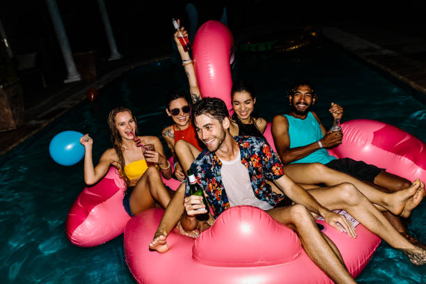 istock Friends having evening pool party 936564134