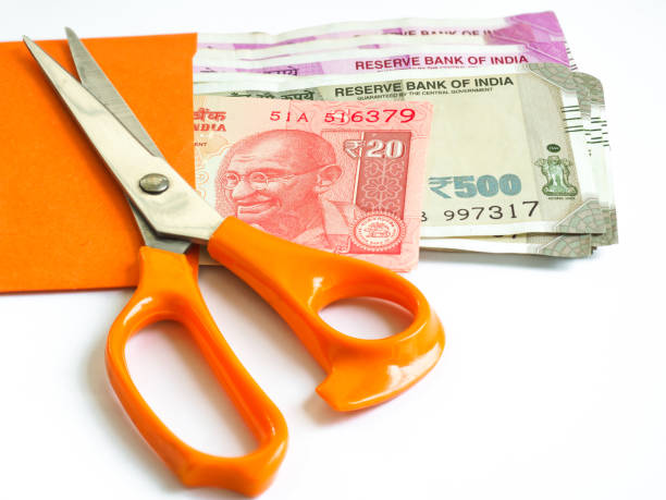 naranja tijeras encima del india dinero en sobres naranja - manilla envelope fotografías e imágenes de stock