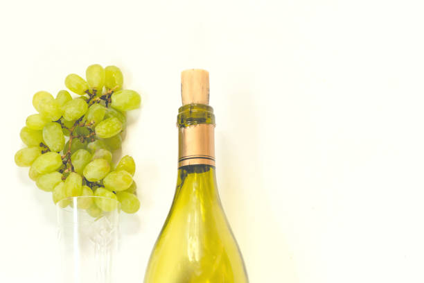istock bottle of wine and a glass with a white grape brush on a white background 936570302