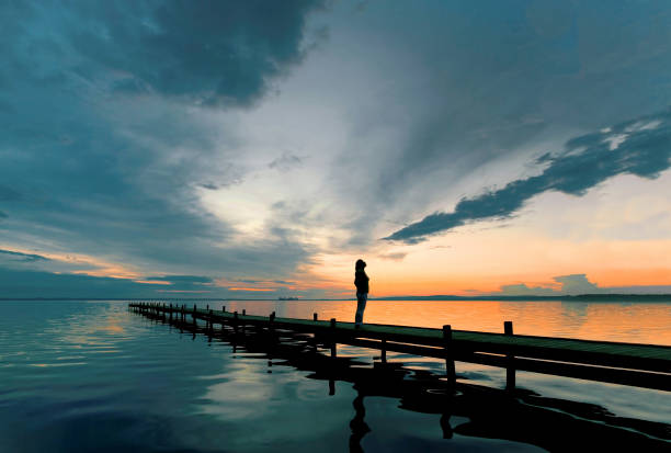 silhouette de femme debout sur la jetée au bord du lac au crépuscule je regarde cloudscape majestueux - ciel romantique photos et images de collection