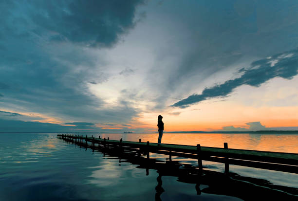 湖畔の桟橋で黄昏見て壮大な cloudscape に立っている女性のシルエット - romantic sky ストックフォトと画像