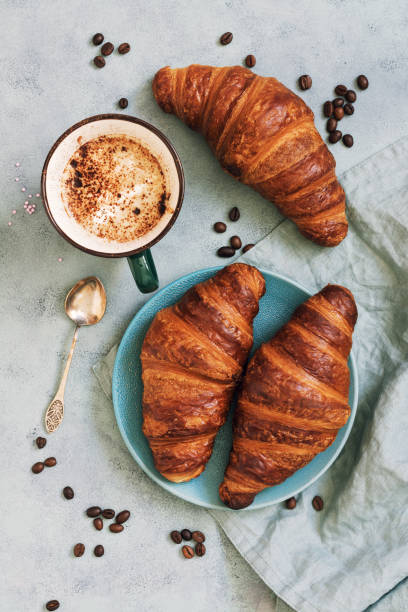 istock French croissant roll with coffee. Appetizing breakfast with pastries. View from above. 936577180