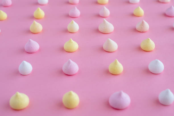 istock Multicolored meringue arranged in an even row on a pink background 936581168