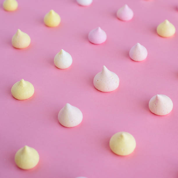 istock Multicolored meringue arranged in an even row on a pink background 936581248