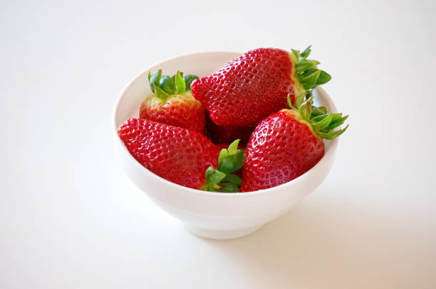 istock Strawberries lie in a white bowl on a white surface. 936584478