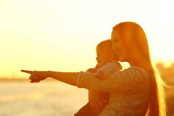 istock Mother and kid son looking away at sunset 936587138