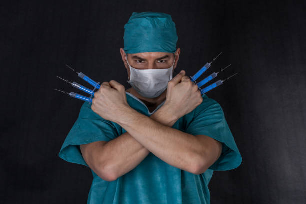 Chirurgien dans scrubs avec bras de seringues ont franchi - Photo