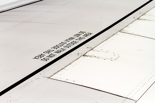 Close-up of wing part of a commercial airplane with instructions