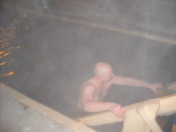 istock Man in an ice-hole. Celebration of baptism. 936594436