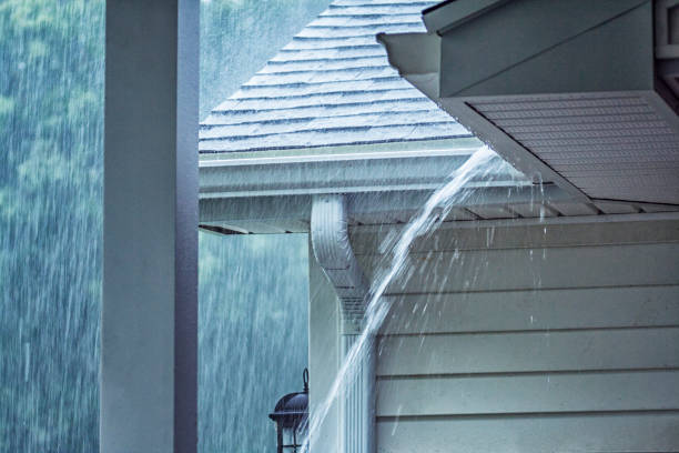 Drenching Rain Storm Water Overflowing Roof Gutter Rain storm water is gushing and splashing off the tile shingle roof - pouring over the overhanging eaves trough aluminum roof gutter system on a suburban residential colonial style house near Rochester, New York State, USA during a torrential July mid summer downpour. downspout stock pictures, royalty-free photos & images