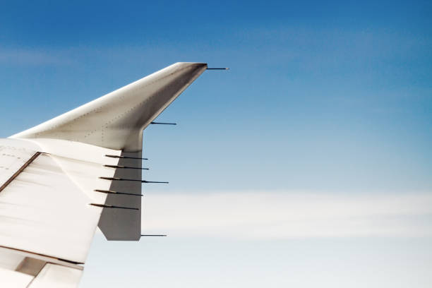 istock Commercial airplane wing against blue sky with clouds 936595294