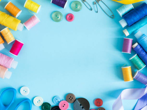 istock Multicolored sewing threads and buttons on blue background with copy space flat lay 936595506