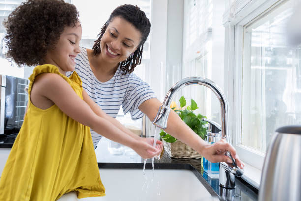 istock Mom helps young daughter wash hands 936598738