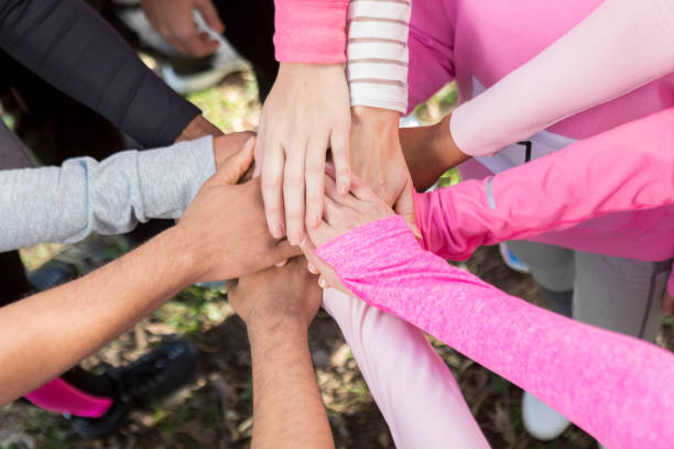 gruppo di persone con le mani unite nell'unità - cancer women womens issues friendship foto e immagini stock