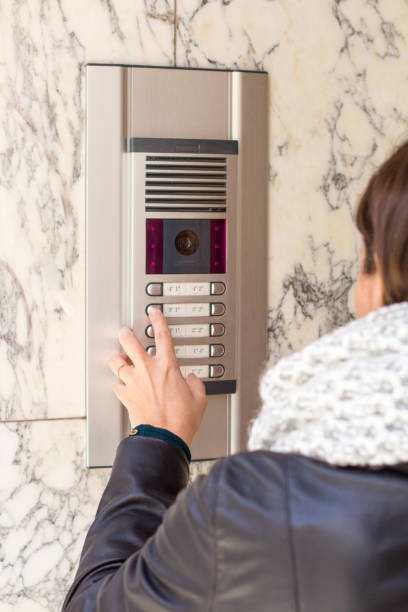 istock Woman pushing the button and talking on the intercom 936600410