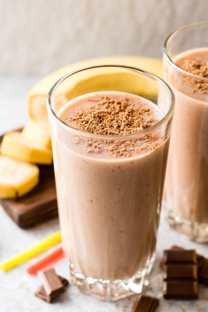 istock Chocolate banana smoothie in glass on gray stone background 936604436