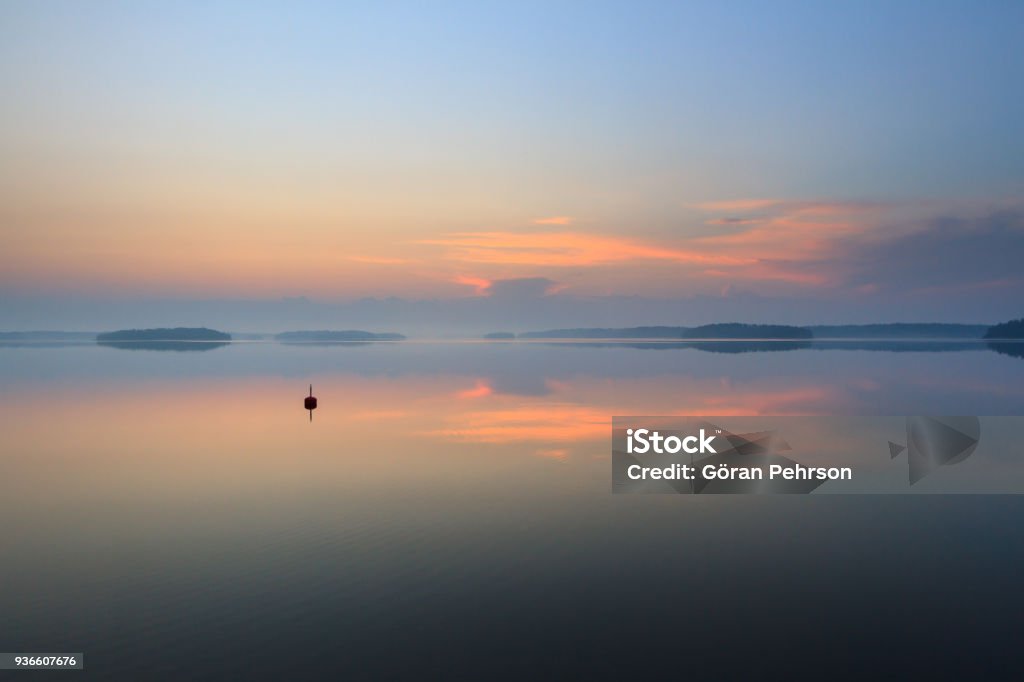 Riflessione solitaria sulla boa sul mare calmo all'alba - Foto stock royalty-free di Arcipelago