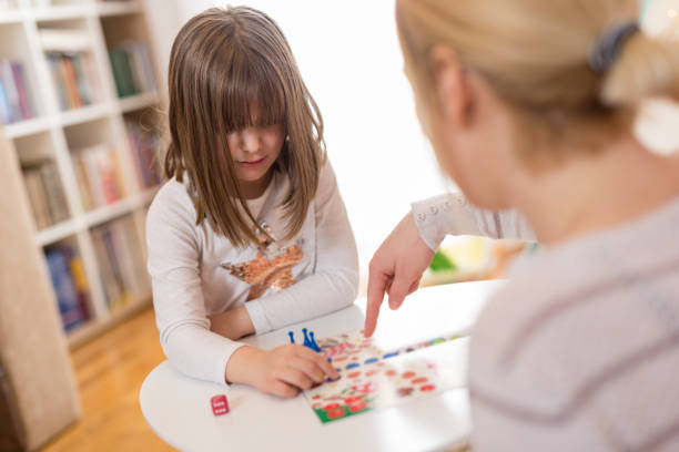 istock Mother and daughter playing ludo board game 936609940