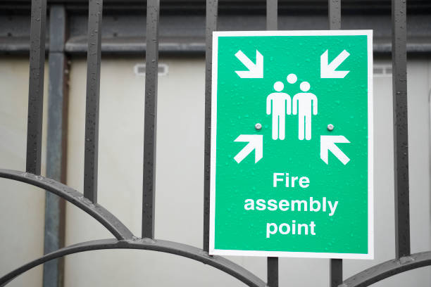 istock Fire assembly point sign green and white for emergency evacuation of office 936611958