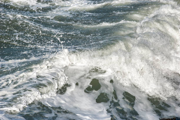 istock Turbulent Ocean Waves Crashing on Shore Rocks 936615508