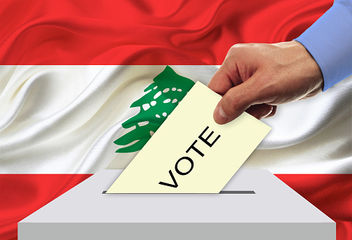 Man voting on elections in Lebanon front of flag