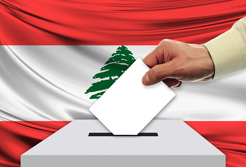 Male inserting flag into ballot box - Lebanon