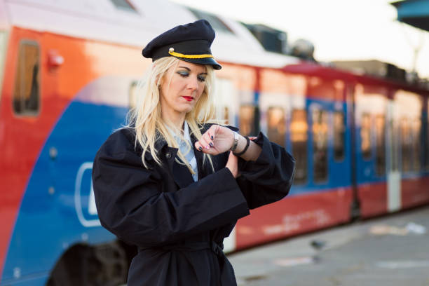 transport conductor checking time The rail transport conductor is checking time on railroad station. transport conductor stock pictures, royalty-free photos & images