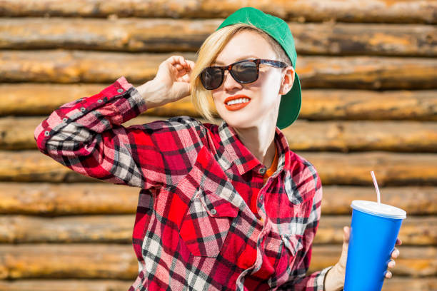 istock Beautiful young woman in hat cap drink cola 936625472