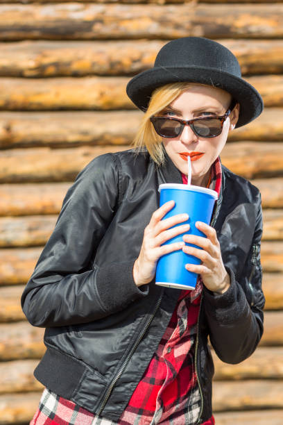 istock Happy young woman drinking outdoors 936625588