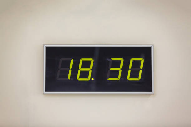 istock Black digital clock on a white background showing time eighteen hours 30 minutes 936625682