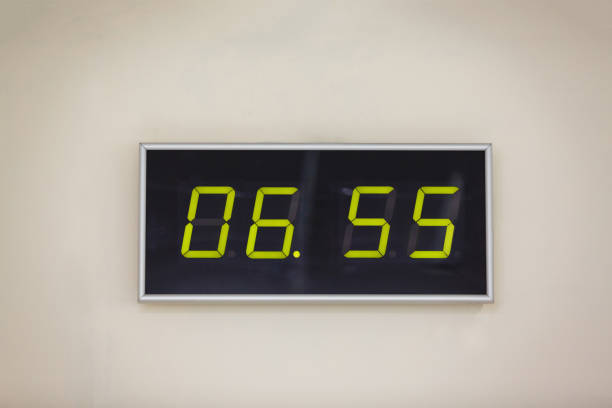istock Black digital clock on a white background showing time 6 hours 55 minutes 936629792